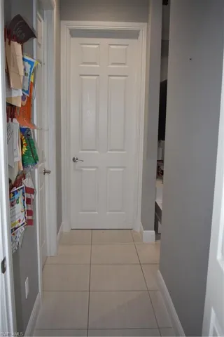 Hallway featuring baseboards and light tile patterned flooring