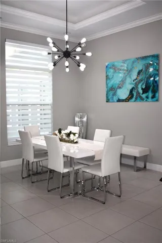 Dining area with hanging lights and ornamental molding