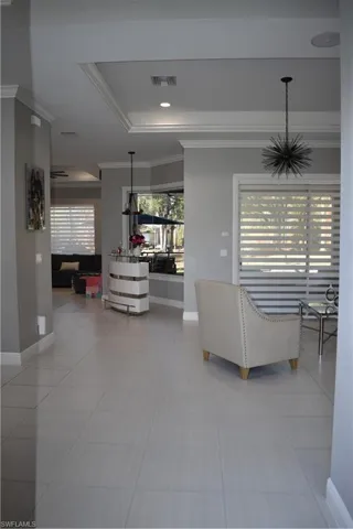 Living area featuring ornamental molding and light tile patterned floors