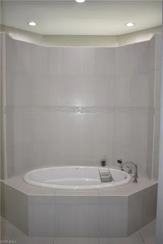 Bathroom featuring a bath, tile patterned flooring, and recessed lighting