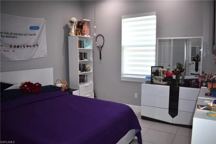 Bedroom with light tile patterned flooring and baseboards