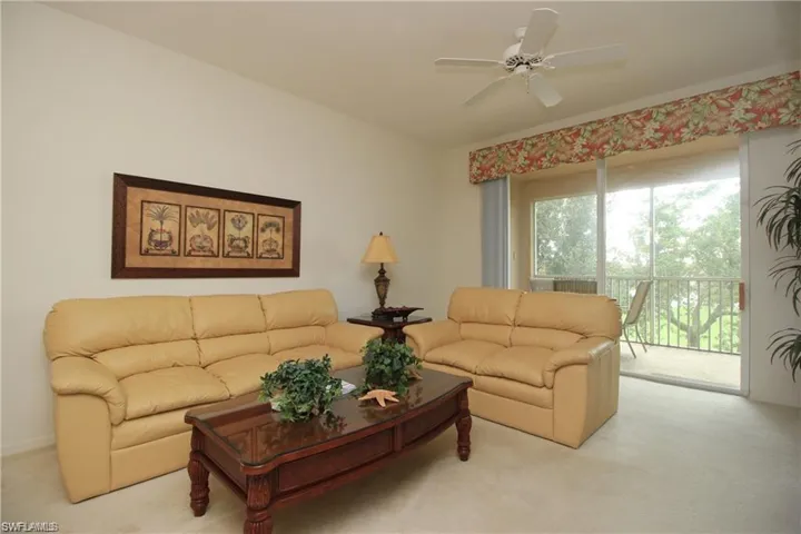 Living room with ceiling fan and light colored carpet
