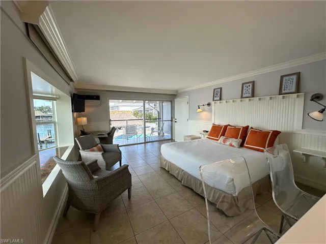 Tiled bedroom featuring access to outside, a wall unit AC, and ornamental molding