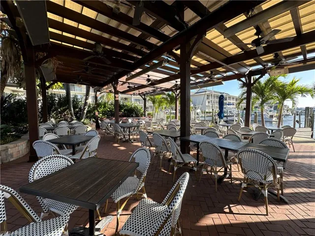 View of patio with ceiling fan and a water view