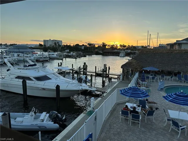 Dock area featuring a community pool, a patio area, and a water view