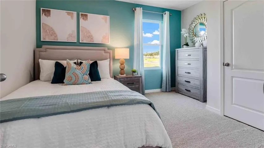 Bedroom featuring neutral carpeting, an accent wall, a single-hung window with a exterior landscape backdrop, and a multi-panel interior door
