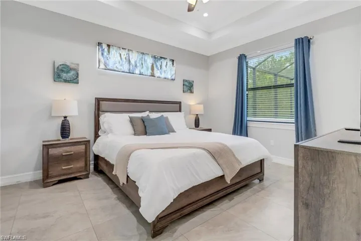 Bedroom featuring a ceiling fan, a raised ceiling, and recessed lighting