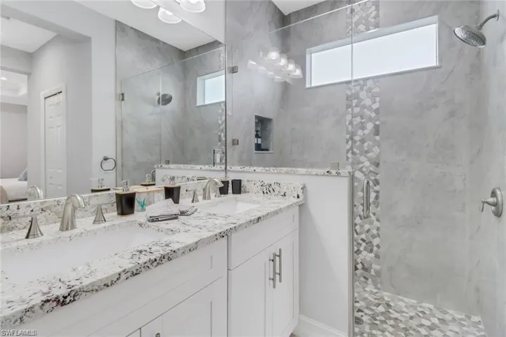 Ensuite bathroom with a marble finish shower and double vanity