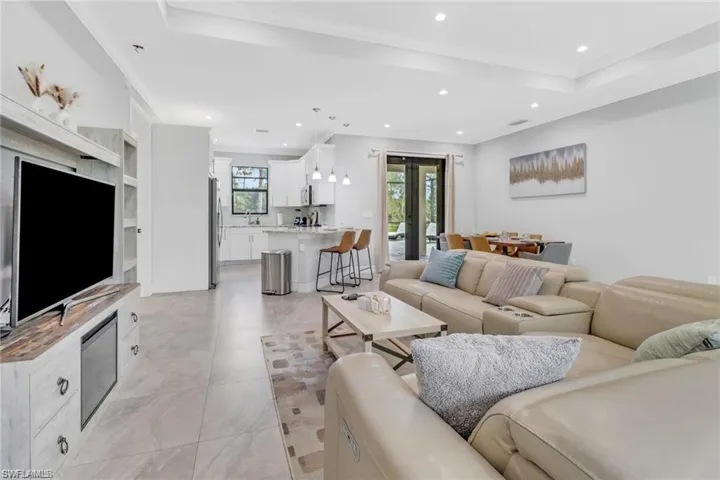 Living room featuring recessed lighting, a raised ceiling, and french doors