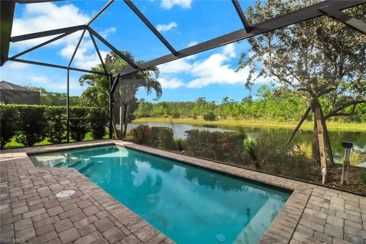 View of swimming pool featuring a lanai, a patio, and a water view