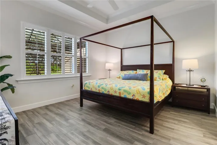 Bedroom with ornamental molding, ceiling fan, and hardwood / wood-style flooring