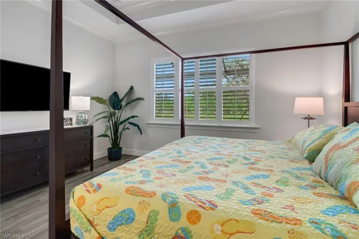 Bedroom featuring crown molding, baseboards, and wood finished floors