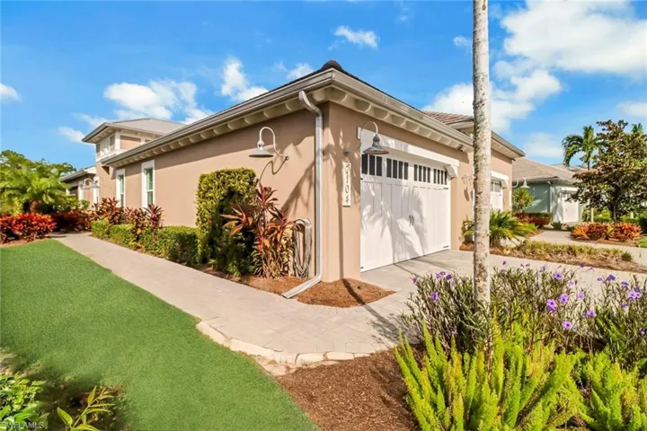 View of side of property featuring a garage, driveway, and stucco siding