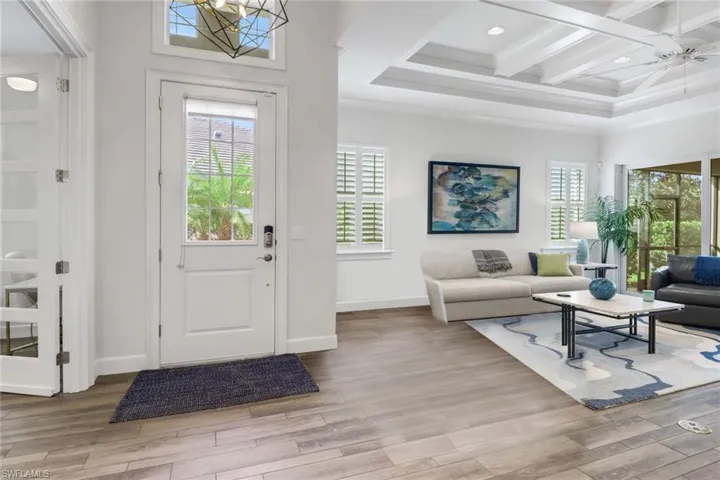 Entryway featuring beam ceiling, wood finished floors, and a healthy amount of sunlight