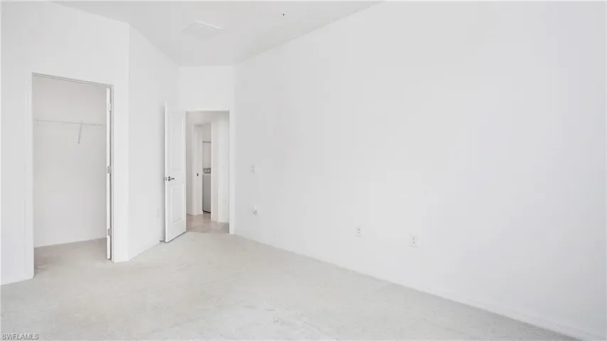 Carpeted room with white walls, baseboards, and two doorways