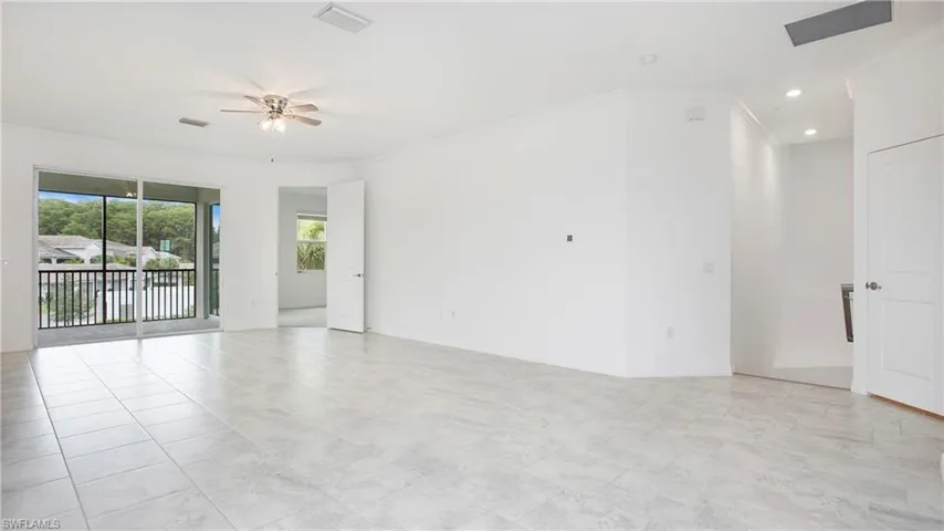 Expansive interior space featuring large format tile flooring and a screened balcony