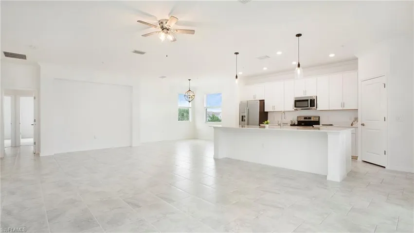 Open-concept living area featuring light-toned tile flooring throughout