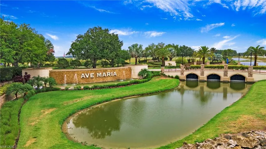 Lush landscaping surrounds a prominent community entrance monument with water features