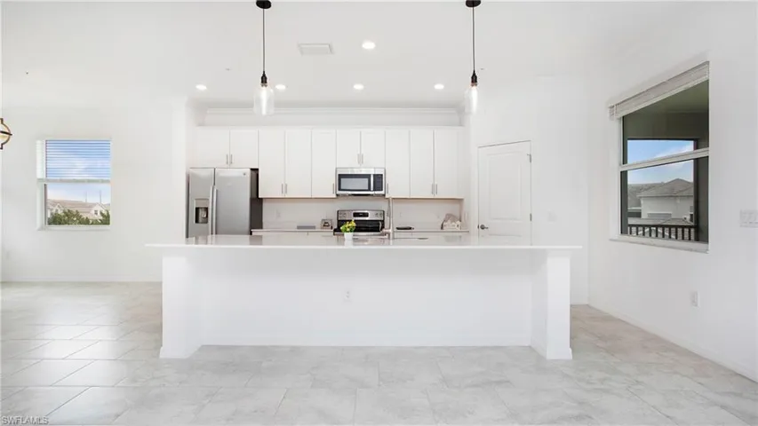 Kitchen featuring a spacious island, white cabinetry, stainless steel appliances, recessed lighting, and tile flooring