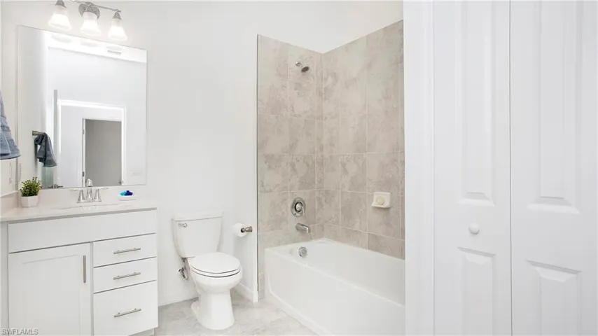 Bathroom with white vanity, integrated sink, and chrome fixtures
