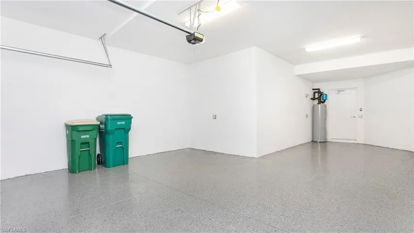 Spacious garage with light grey speckled epoxy flooring and bright overhead fluorescent lighting