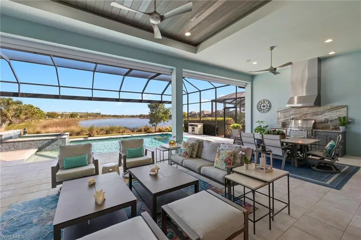 View of patio featuring an outdoor living space, ceiling fan, a water view, and area for grilling