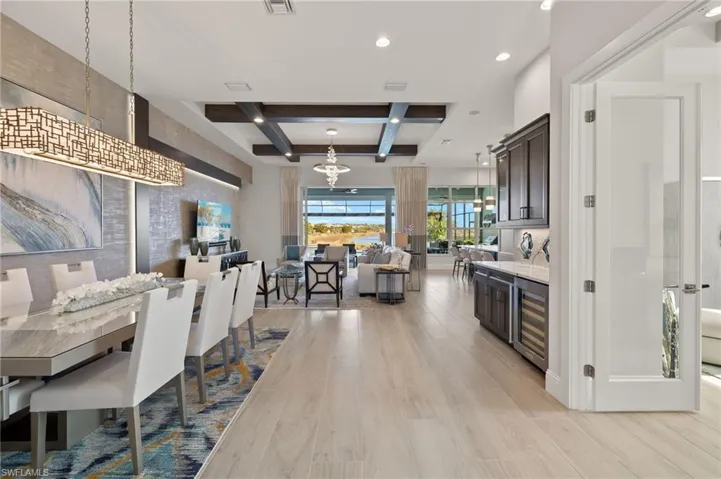 Dining area with beamed ceiling, coffered ceiling, and light wood-type flooring
