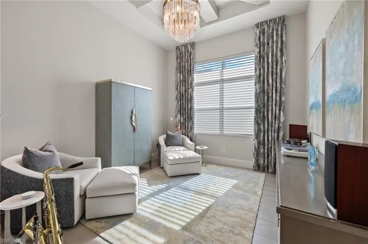 Living area featuring light wood-type flooring and a notable chandelier