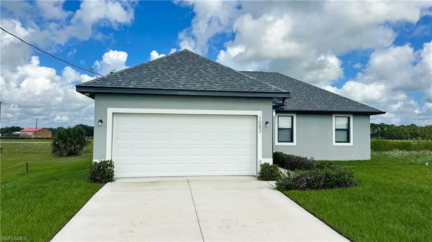 Contemporary exterior with a two-car garage, concrete driveway, and a shingle roof