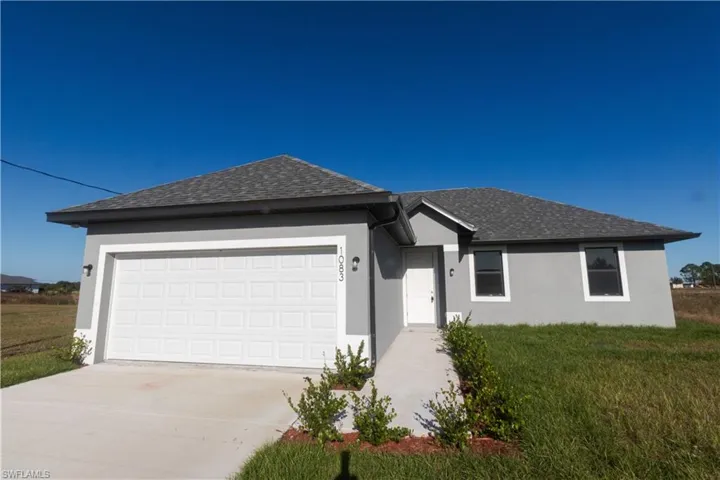 Single-story residence featuring a two-car garage, concrete driveway, and concrete walkway