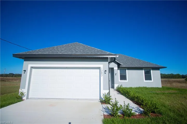 Single-story residence featuring a gray exterior, white garage door, and a gray shingle roof