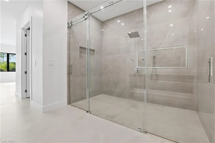 Bathroom featuring a marble finish shower, recessed lighting, and finished concrete floors