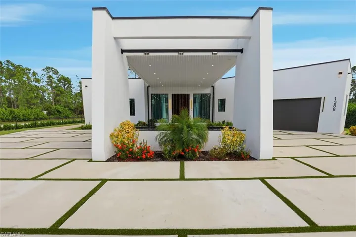 View of front of home featuring stucco siding, concrete driveway, and a garage