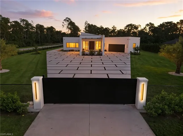 Contemporary house featuring driveway, stucco siding, a garage, and a patio area