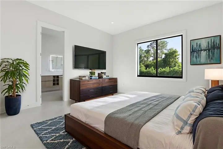 Bedroom featuring finished concrete flooring and connected bathroom