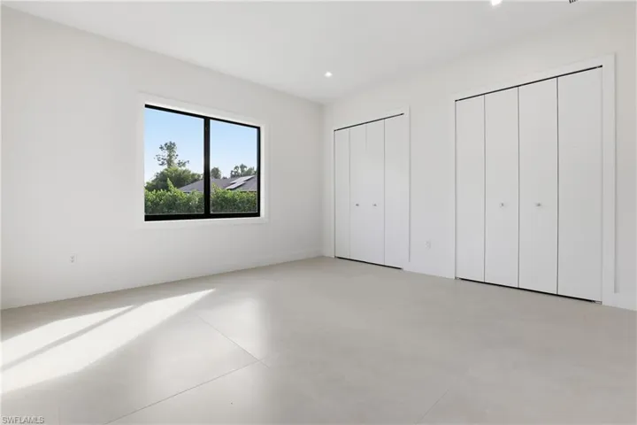 Unfurnished bedroom featuring two closets, finished concrete flooring, and recessed lighting