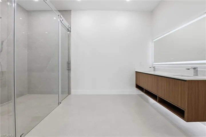 Full bathroom with a marble finish shower, double vanity, and recessed lighting