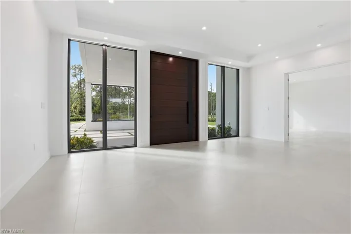 Unfurnished room with plenty of natural light, floor to ceiling windows, and recessed lighting