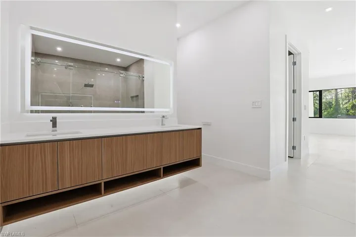 Full bathroom with a shower stall, double vanity, and recessed lighting