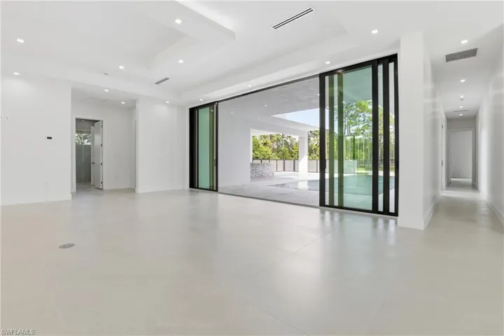 Unfurnished room featuring recessed lighting, floor to ceiling windows, and a raised ceiling