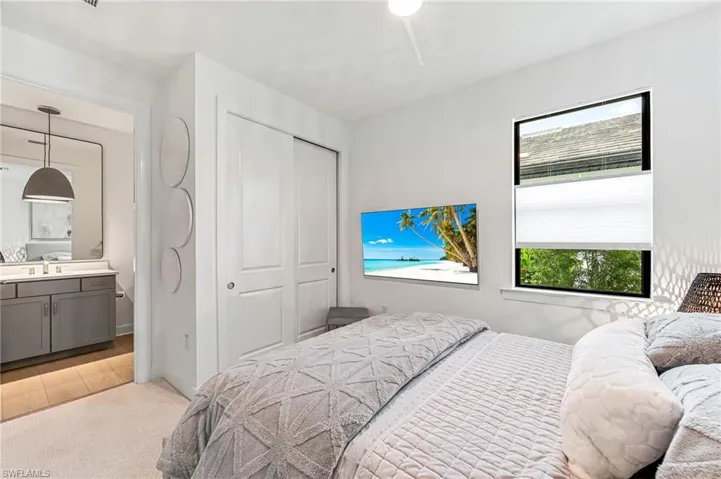 Bedroom featuring light hardwood / wood-style floors, ensuite bathroom, sink, and a closet
