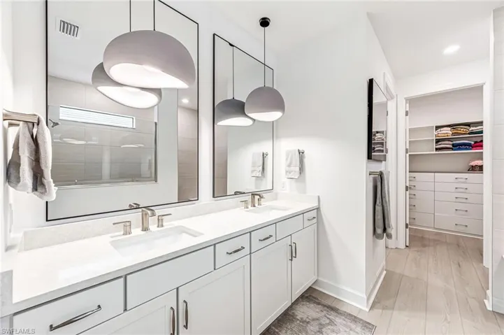 Bathroom featuring vanity, a tile shower, and hardwood / wood-style floors