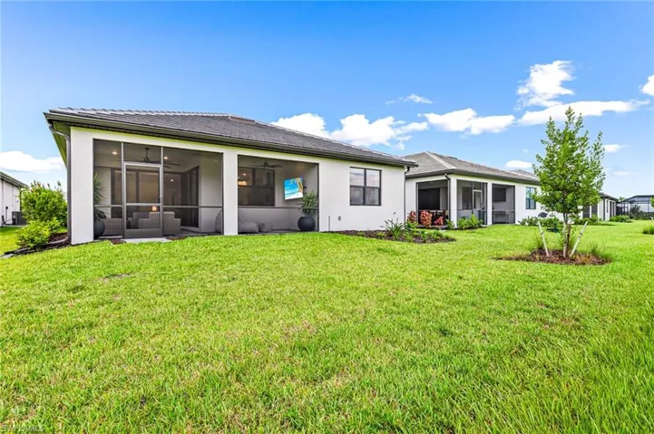 Rear view of house with a lawn and a sunroom