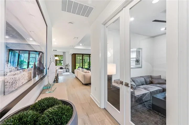 Hallway with french doors and light hardwood / wood-style flooring