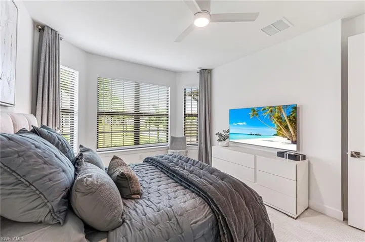 Bedroom featuring ceiling fan and light carpet
