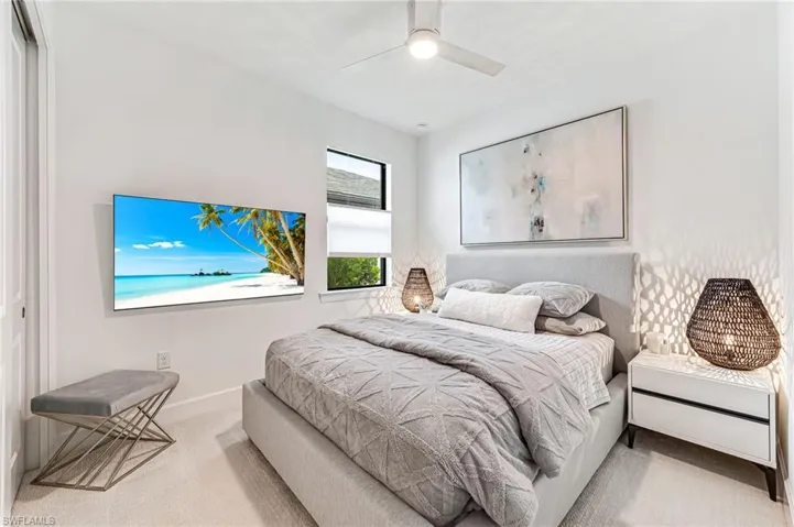Bedroom with light colored carpet, ceiling fan, and a closet