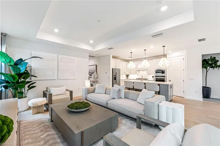 Living room featuring light hardwood / wood-style flooring and a tray ceiling