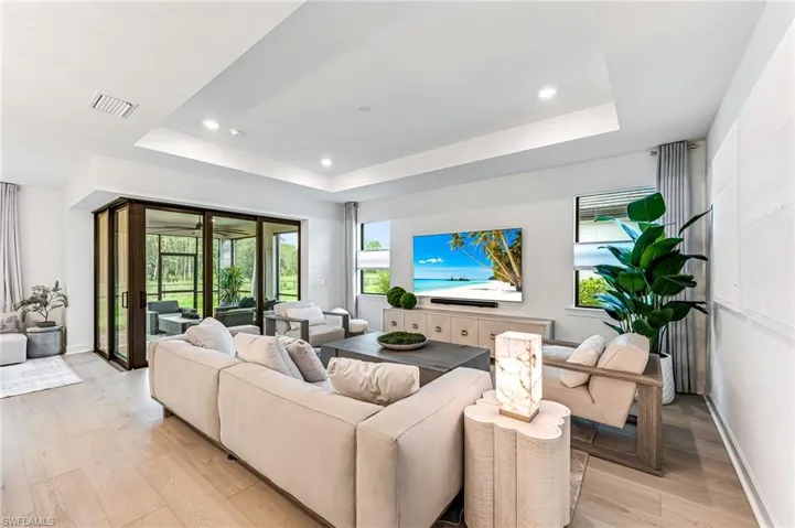 Living room with light wood-type flooring and a raised ceiling