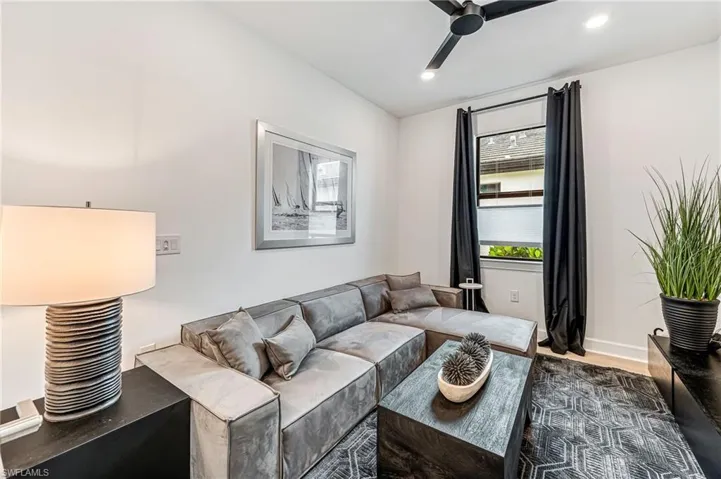 Living room with dark wood-type flooring and ceiling fan
