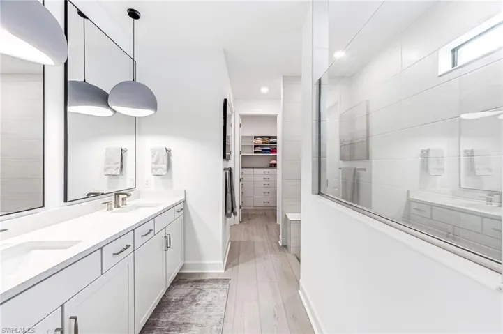 Bathroom featuring vanity, a shower, and wood-type flooring